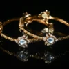 White lotus 2pc bangles with gold finish and floral detailing by nischala fashions