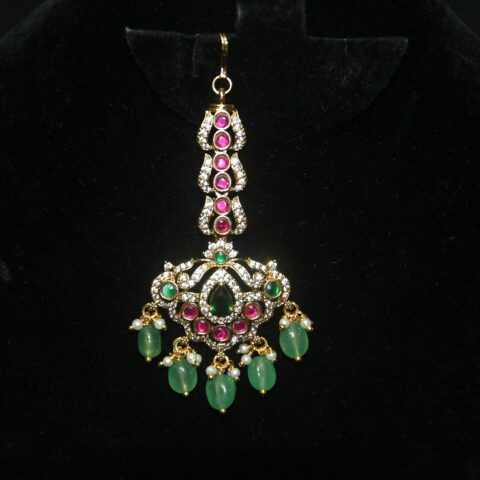 Jadau kundan maang tikka with green beads hanging, regal traditional jewelry by Nischala Fashions.