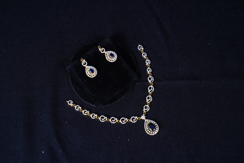 Simple diamond necklace with earrings in blue, featuring sparkling stones and elegant design by Nischala Fashions.