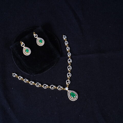 Simple diamond necklace with earrings in green, adorned with shimmering diamonds and lush green stones by Nischala Fashions.